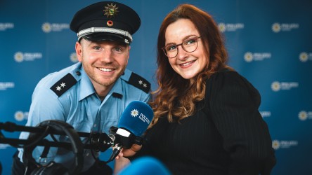 Das Moderationsteam: Polizeioberkommissar Christian in Uniform und Redakteurin Franzi. Beide lächeln in die Kamera.