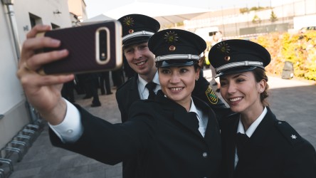 Selfie: Zwei junge Frauen und ein Mann fotografieren sich mit ihren neuen Polizeisternen.
