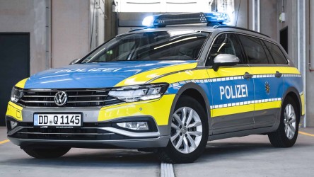 Der interaktive Funkstreifenwagen der Polizei Sachsen steht in einer Halle. Das Blaulicht ist für das Foto aktiviert.
